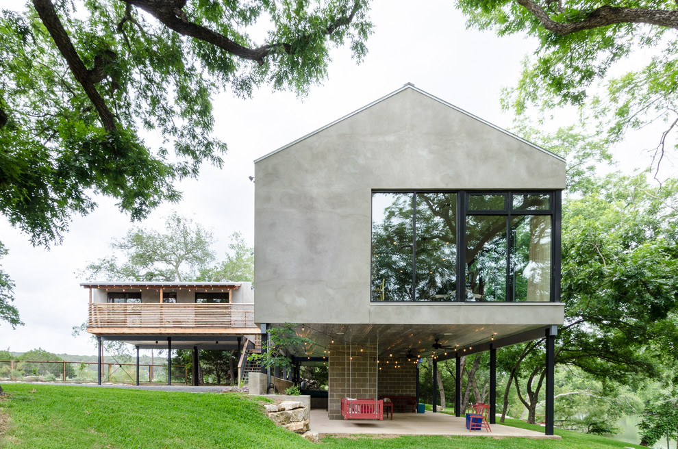 Modernes Haus mit Mix-Fassade, grauer Fassadenfarbe und Satteldach in Austin