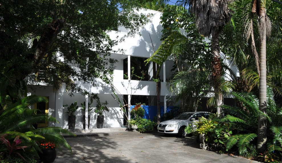 Bild på ett tropiskt vitt hus, med två våningar