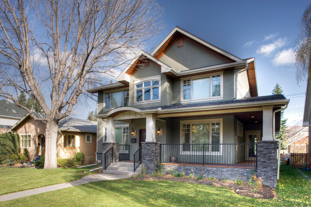 Mid-sized craftsman gray two-story stucco exterior home idea in Calgary with a shingle roof