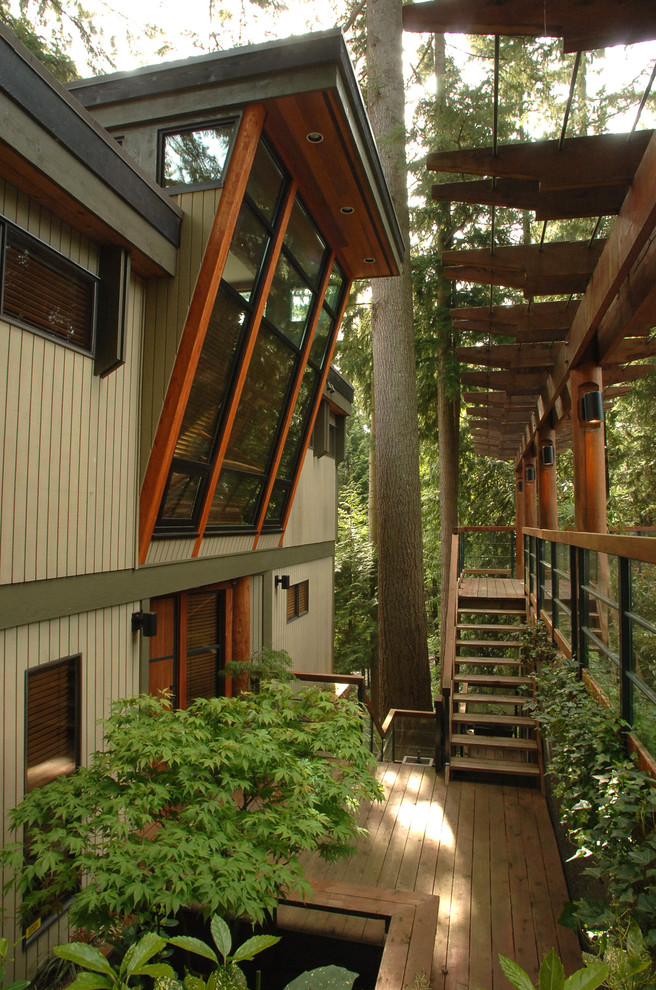 Immagine della villa grigia contemporanea con rivestimento in legno e tetto piano