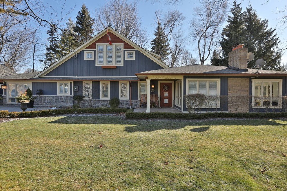 Example of a large transitional blue one-story mixed siding exterior home design in Toronto with a shingle roof