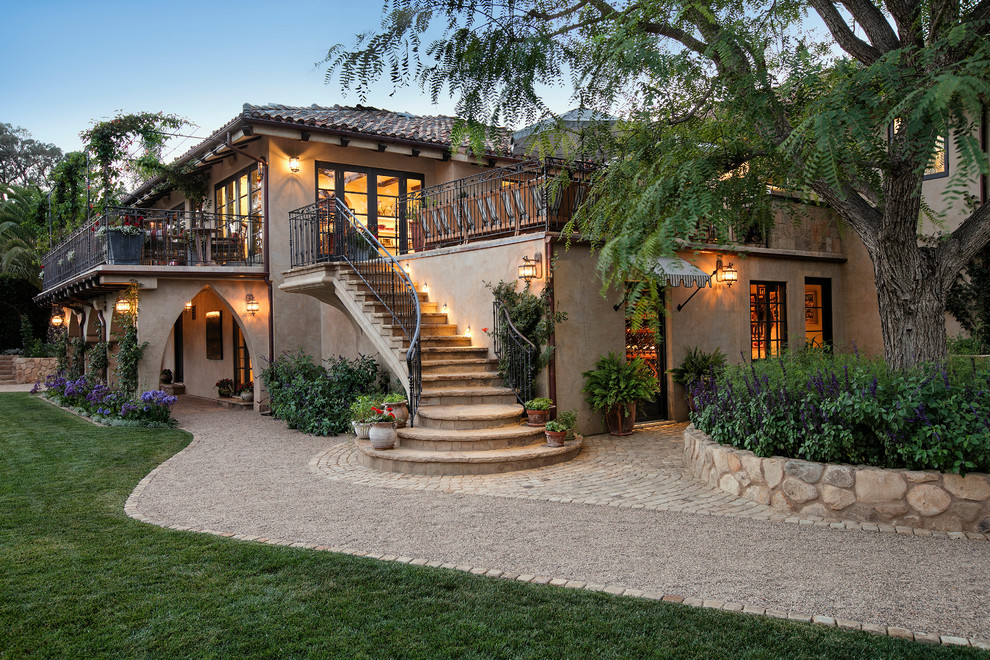 Large mediterranean beige two-story stucco exterior home idea in Santa Barbara