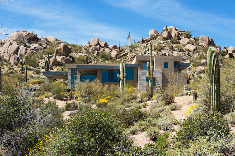 Inspiration for an expansive and gey modern split-level house exterior in Phoenix with stone cladding and a flat roof.