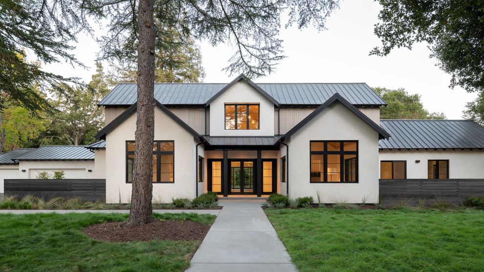Exemple d'une façade de maison blanche tendance en stuc à un étage avec un toit en métal, un toit à deux pans et un toit noir.
