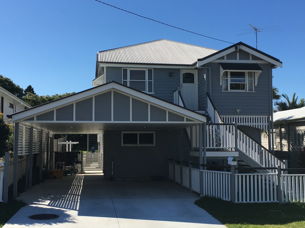 Photo of a medium sized and gey traditional two floor detached house in Brisbane with wood cladding, a pitched roof and a metal roof.