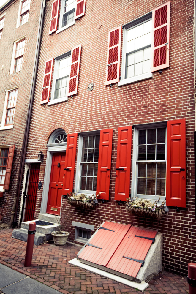 Aménagement d'une façade de maison rouge classique en brique à deux étages et plus.