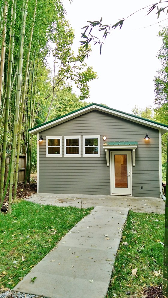 Mittelgroße Moderne Holzfassade Haus mit grauer Fassadenfarbe und Satteldach in Sonstige