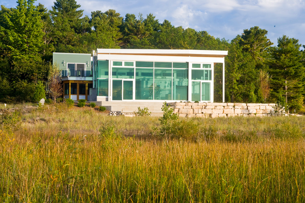 Foto della facciata di una casa verde moderna a due piani di medie dimensioni con rivestimenti misti e tetto piano