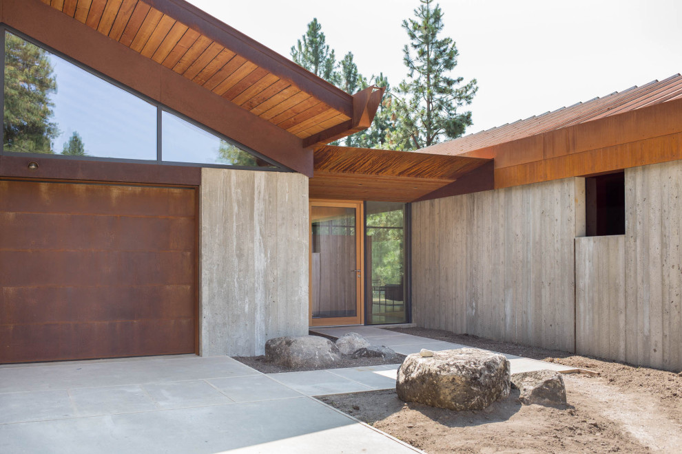Foto de fachada de casa gris rústica de tamaño medio de dos plantas con revestimiento de hormigón, tejado a dos aguas y tejado de metal