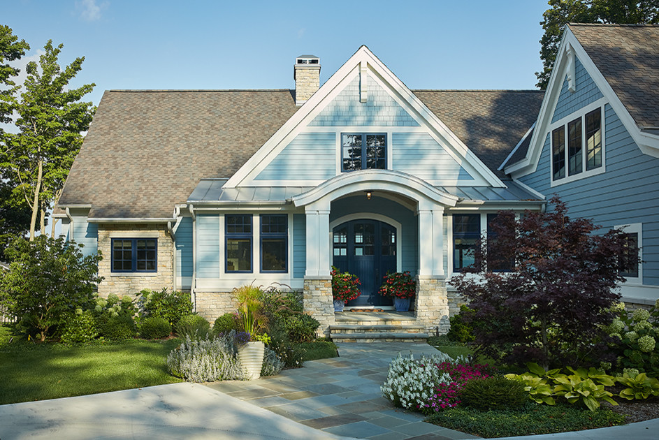 Ejemplo de fachada de casa azul clásica grande de tres plantas con revestimientos combinados, tejado a dos aguas y tejado de varios materiales
