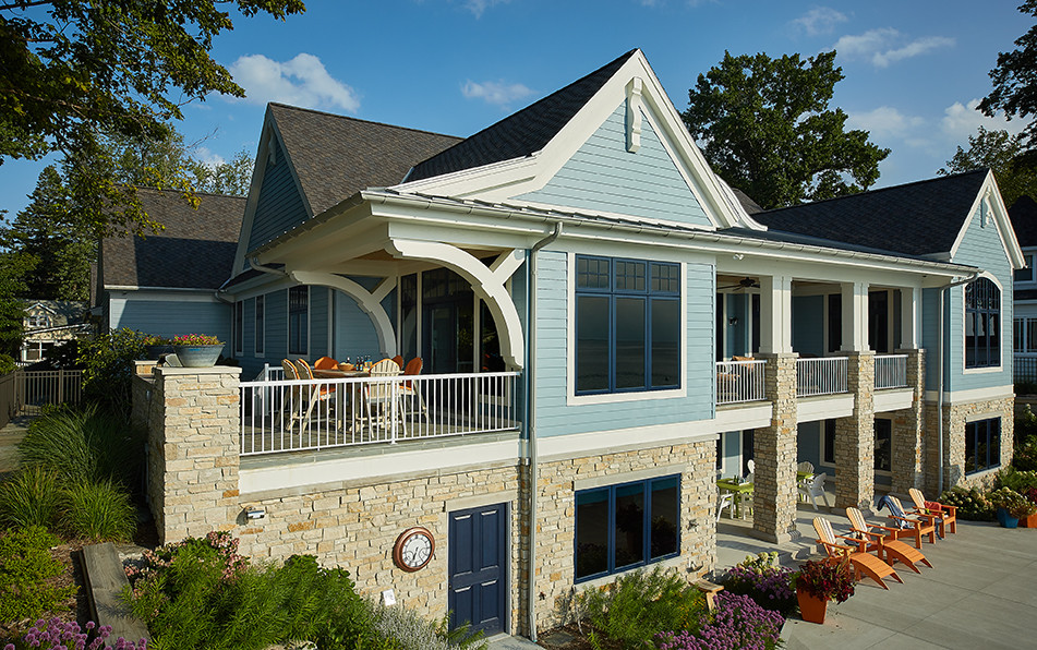 Modelo de fachada de casa azul clásica grande de tres plantas con revestimientos combinados, tejado a dos aguas y tejado de varios materiales