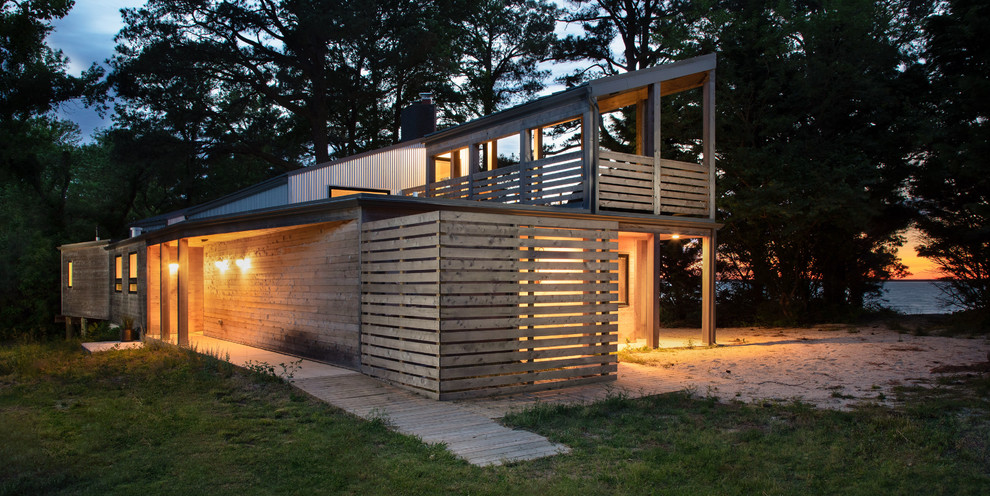 Cette photo montre une petite façade de maison moderne de plain-pied avec un revêtement mixte, un toit plat et un toit mixte.