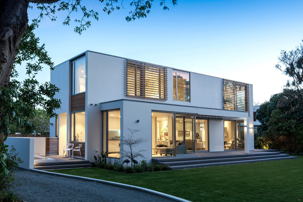 Imagen de fachada de casa blanca actual de dos plantas con revestimientos combinados y tejado plano