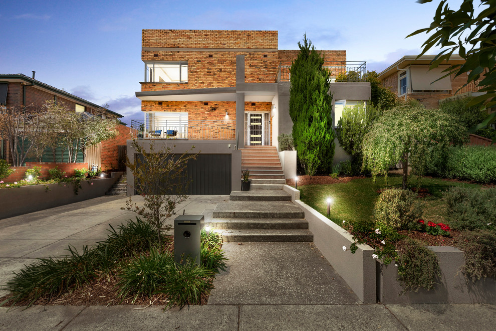 This is an example of a red contemporary brick detached house in Melbourne with a flat roof.