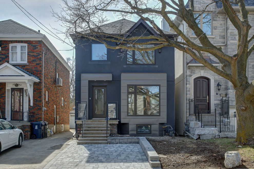 This is an example of a small and gey contemporary two floor render house exterior in Toronto with a pitched roof.