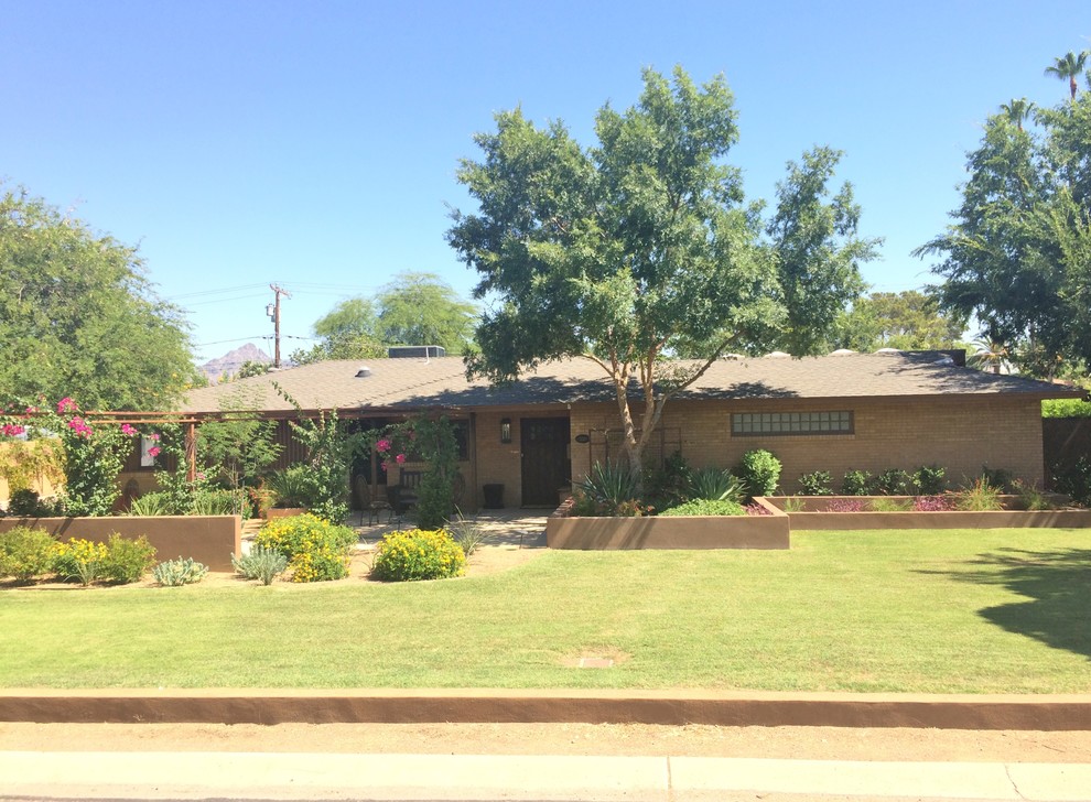 Photo of a medium sized and brown retro bungalow glass house exterior in Phoenix.