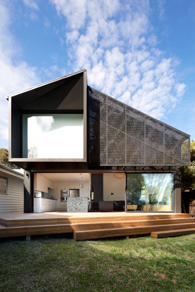 This is an example of a medium sized and gey contemporary split-level detached house in Melbourne with metal cladding, a pitched roof and a metal roof.
