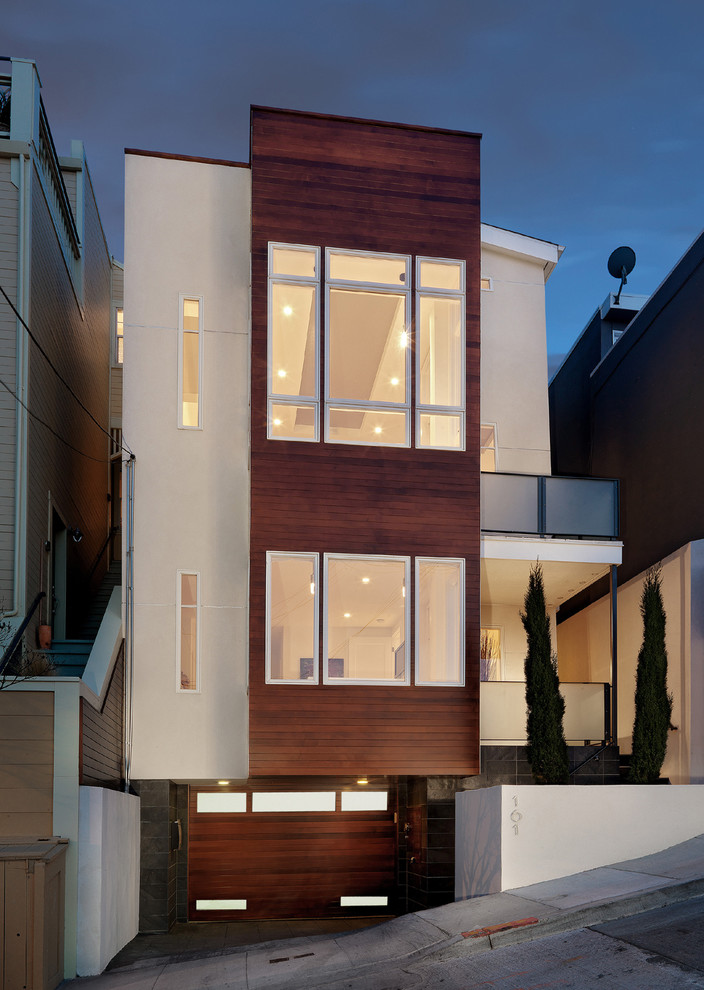 Idee per la facciata di un appartamento contemporaneo con rivestimento in legno e terreno in pendenza