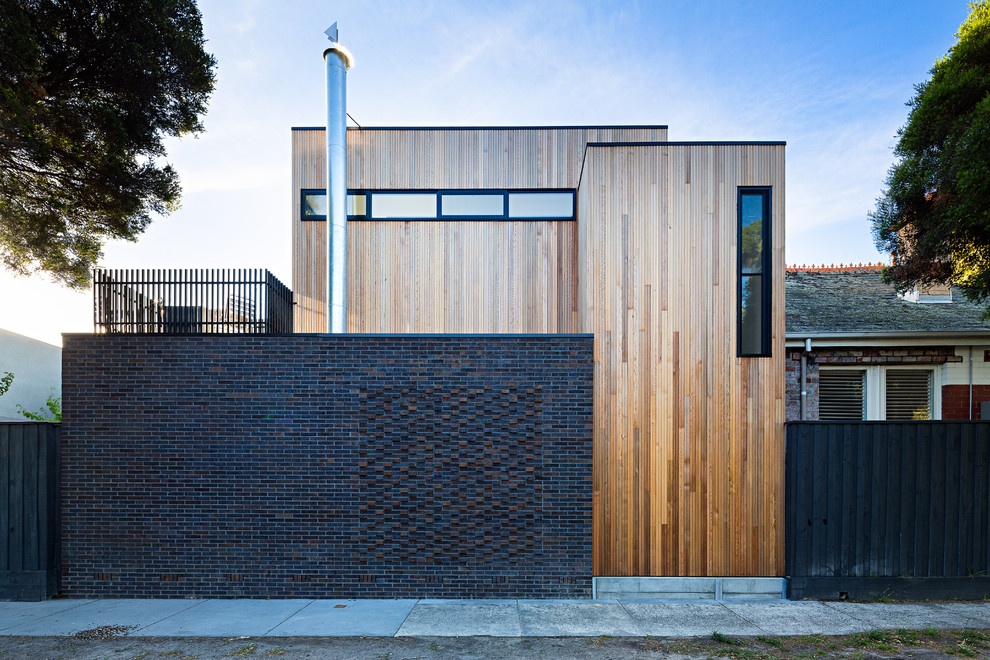 Photo of a large contemporary two floor house exterior in Melbourne with wood cladding and a flat roof.