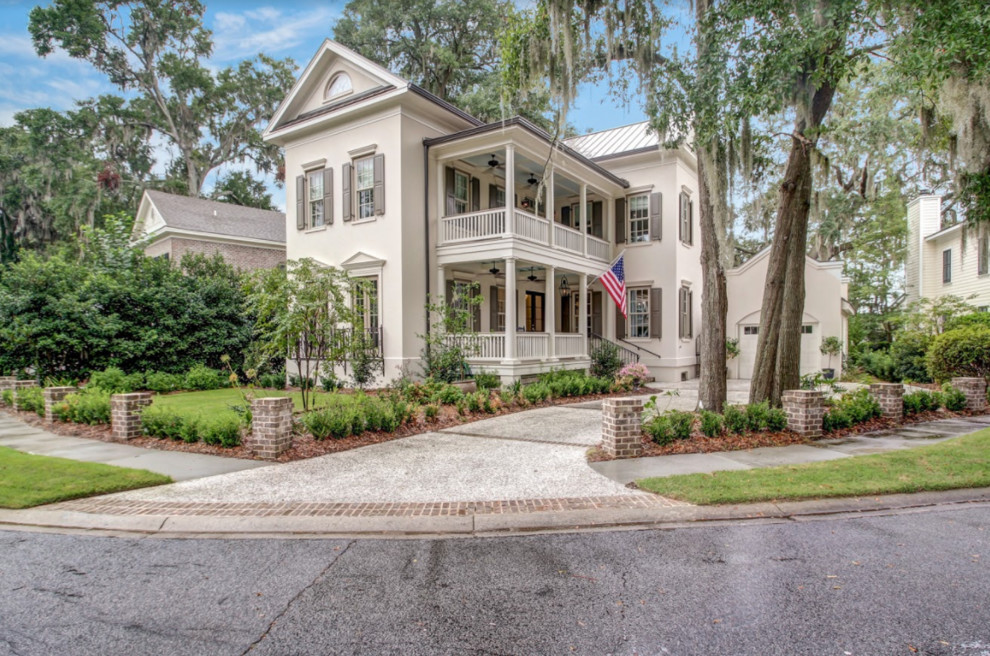 Inspiration for a timeless beige two-story stucco house exterior remodel in Atlanta with a metal roof