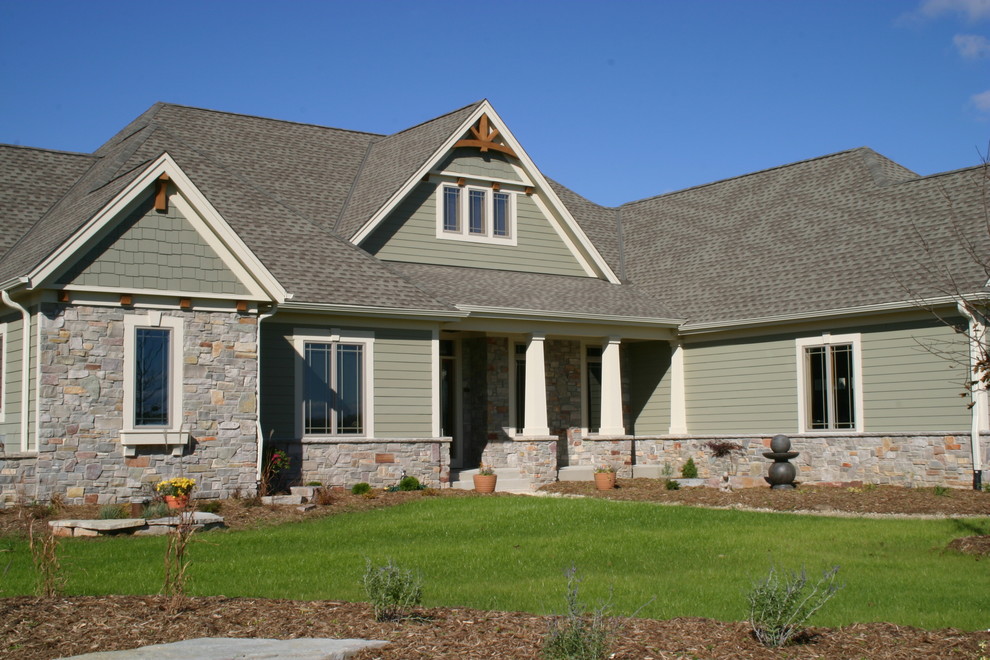 Aménagement d'une grande façade de maison verte classique en panneau de béton fibré à un étage avec un toit à deux pans.
