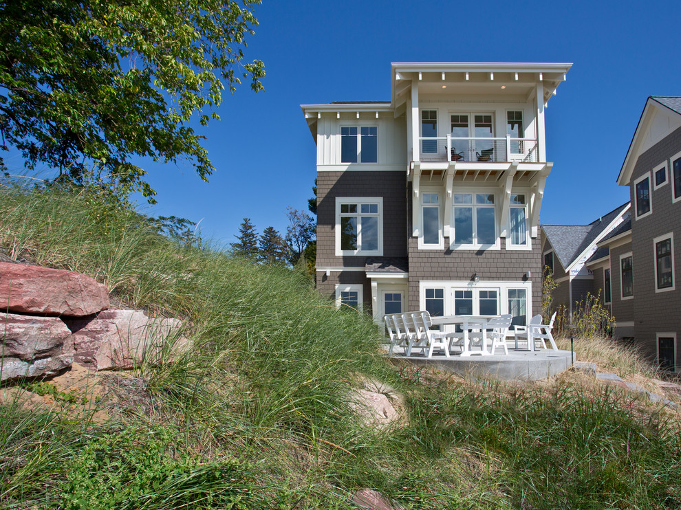 Стильный дизайн: трехэтажный, серый дом в морском стиле с комбинированной облицовкой - последний тренд