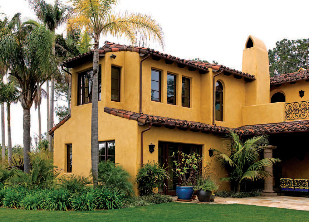 Large tuscan two-story stucco exterior home photo in San Diego with a tile roof