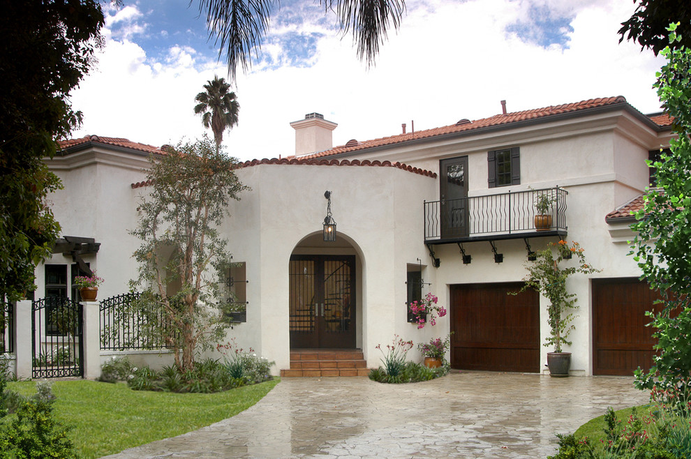 Immagine della facciata di una casa grande bianca mediterranea a due piani con rivestimento in stucco