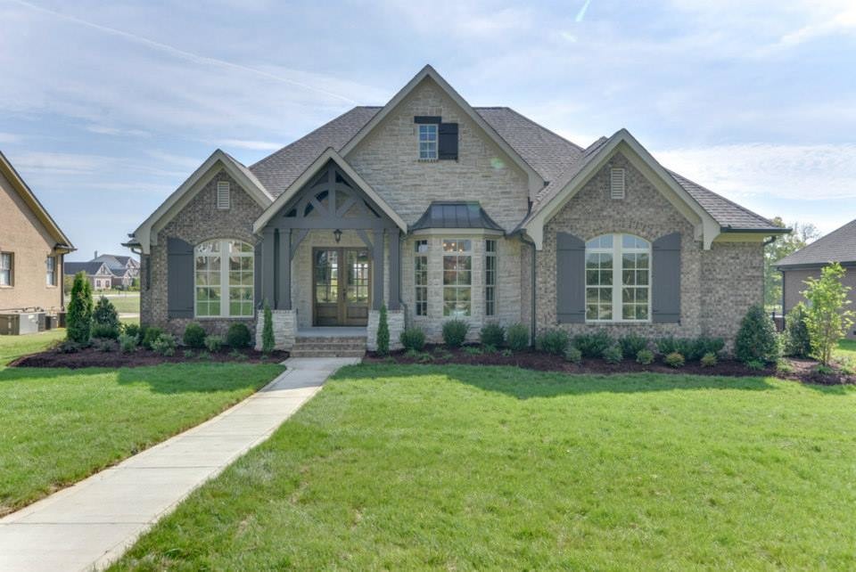 Inspiration for a large timeless beige one-story brick gable roof remodel in Nashville