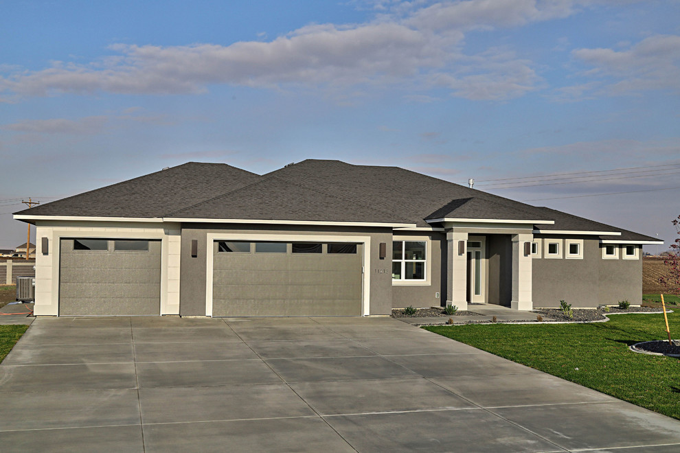 Mid-sized contemporary gray one-story stucco house exterior idea in Seattle with a hip roof and a shingle roof