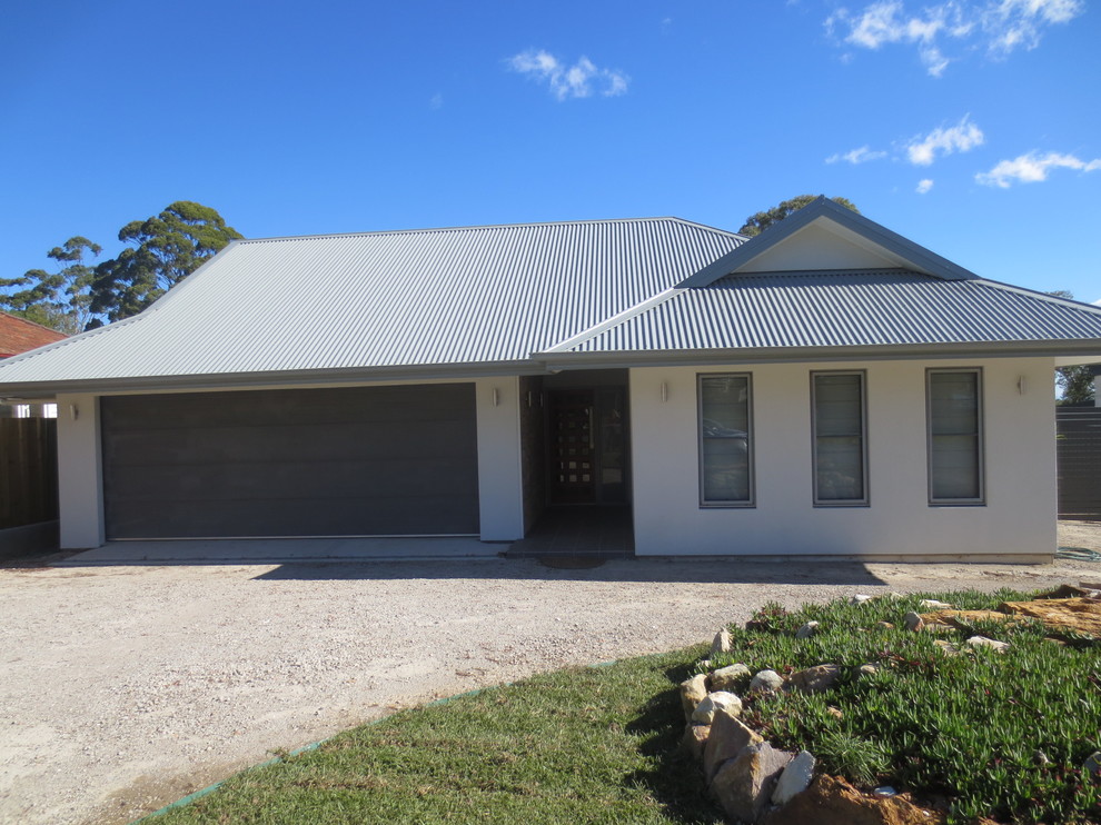 This is an example of a medium sized and white contemporary bungalow house exterior in Sydney.