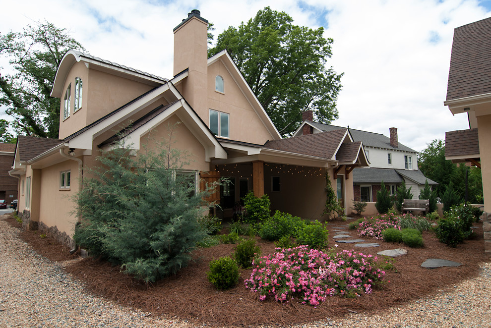 Exemple d'une façade de maison beige nature en stuc à un étage et de taille moyenne avec un toit à quatre pans et un toit en métal.