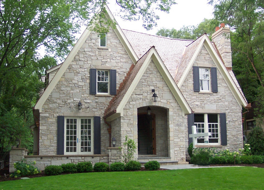 Inspiration pour une façade de maison grise traditionnelle en pierre à un étage avec un toit à deux pans.