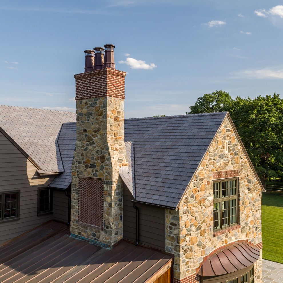 Стильный дизайн: большой, двухэтажный, коричневый частный загородный дом в классическом стиле с двускатной крышей, крышей из гибкой черепицы и облицовкой из камня - последний тренд