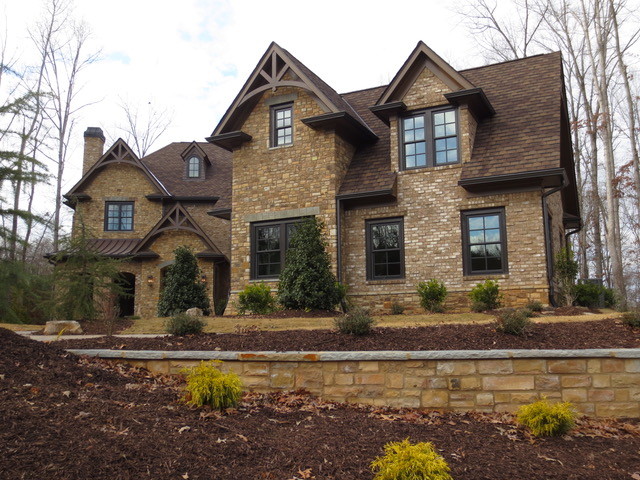 This is an example of a large and brown traditional two floor house exterior in Atlanta with mixed cladding and a pitched roof.