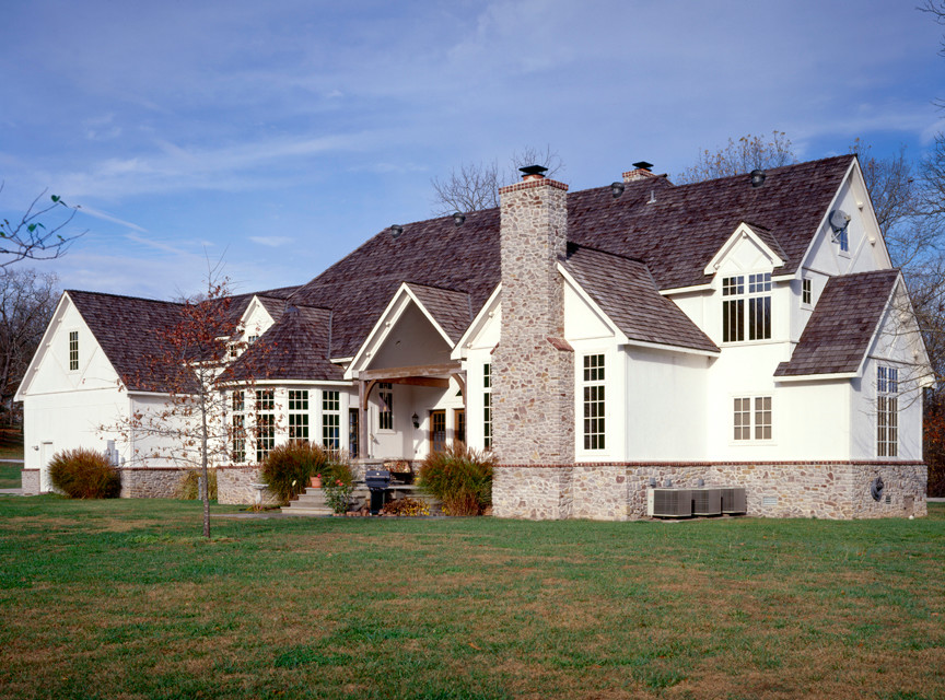 Ejemplo de fachada blanca clásica de tamaño medio de tres plantas con revestimientos combinados y tejado a dos aguas