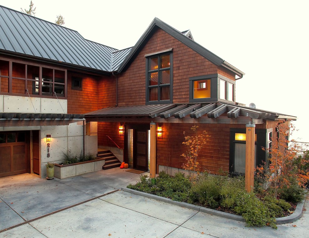 Стильный дизайн: деревянный, большой, коричневый, трехэтажный частный загородный дом в викторианском стиле с двускатной крышей и металлической крышей - последний тренд