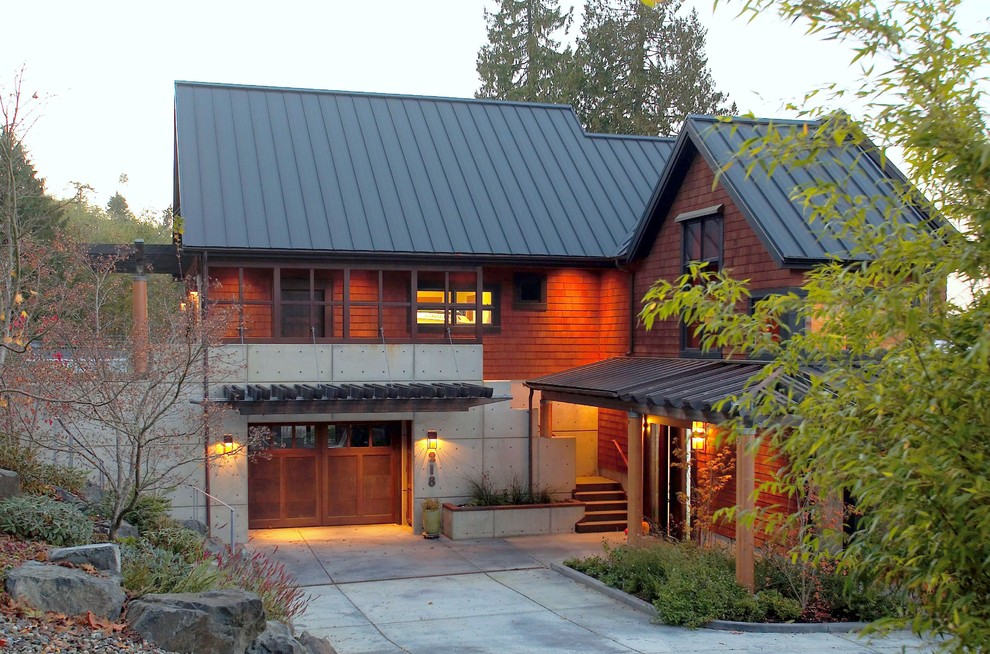 Réalisation d'une grande façade de maison marron tradition en bois à deux étages et plus avec un toit à deux pans et un toit en métal.