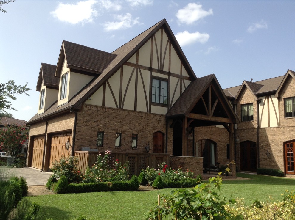 Foto de fachada de casa marrón de estilo americano grande de dos plantas con revestimiento de ladrillo y tejado a dos aguas