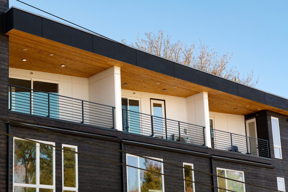 Esempio della facciata di un appartamento moderno a tre piani di medie dimensioni con rivestimento in legno