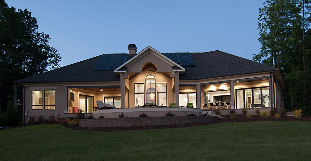 Diseño de fachada de casa beige actual grande de una planta con revestimientos combinados, tejado a dos aguas y tejado de varios materiales