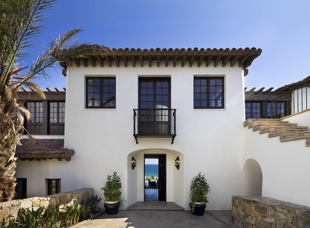 Стильный дизайн: двухэтажный, белый дом среднего размера в средиземноморском стиле с облицовкой из цементной штукатурки и плоской крышей - последний тренд