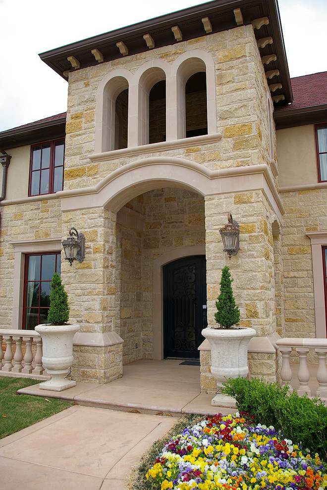 Foto della facciata di una casa grande mediterranea a due piani con rivestimento in pietra