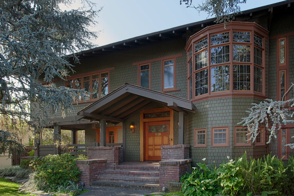 Cette image montre une grande façade de maison verte craftsman en bois à un étage avec un toit à deux pans.