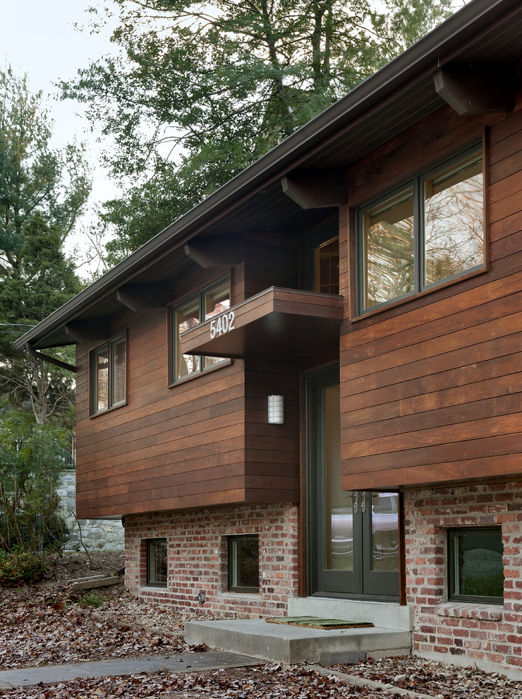 Imagen de fachada contemporánea a niveles con revestimiento de madera