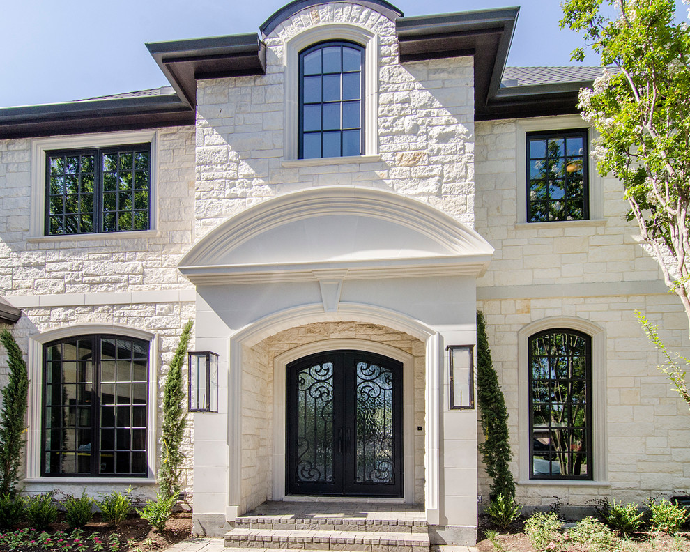 Photo of a medium sized and beige classic two floor house exterior in Dallas with stone cladding and a hip roof.