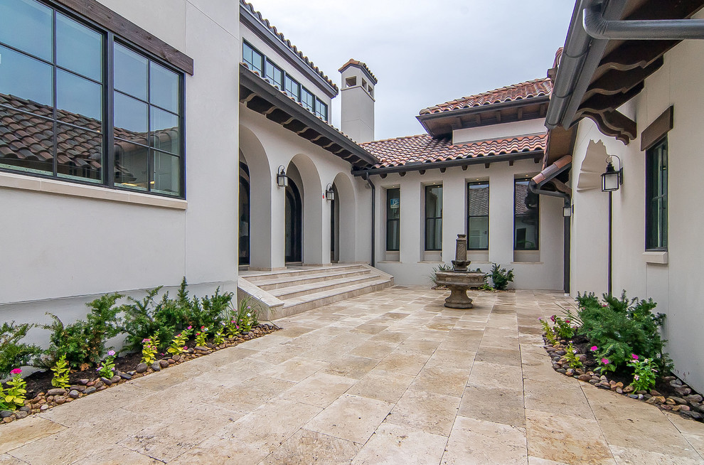 Large and white mediterranean two floor render detached house in Dallas with a pitched roof and a tiled roof.