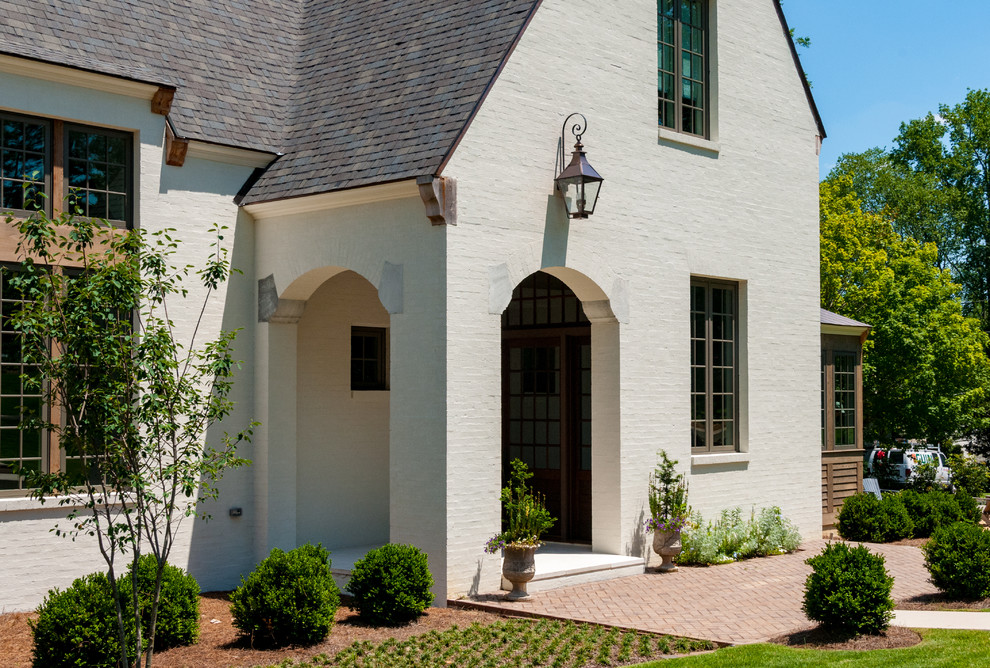 На фото: трехэтажный, белый частный загородный дом среднего размера в классическом стиле с комбинированной облицовкой, двускатной крышей и крышей из гибкой черепицы с