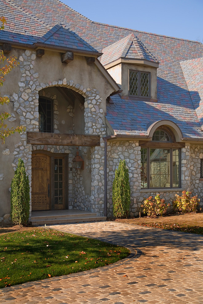 Aménagement d'une très grande façade de maison beige classique en pierre à deux étages et plus avec un toit mixte.