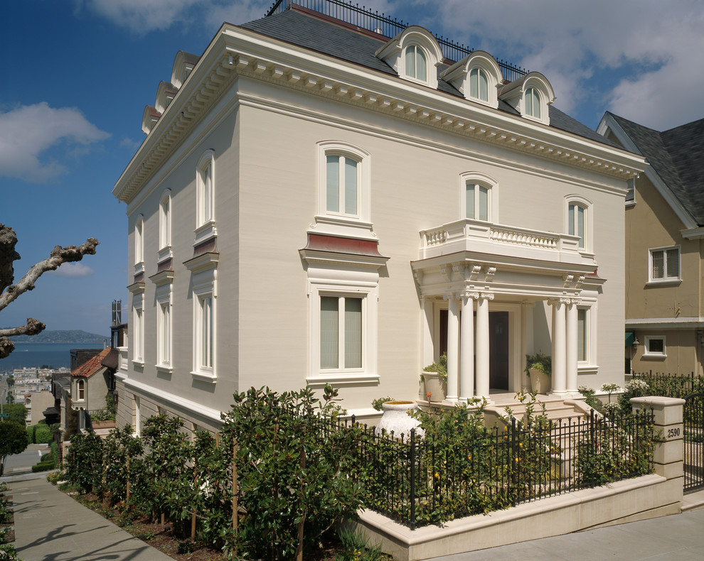 Foto de fachada beige clásica grande con tejado a cuatro aguas